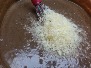 Really semi blurry pic of cheese going into the soup. Salsa is already in it...